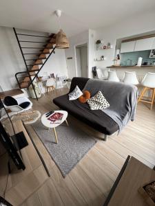 a living room with a black couch and a table at Le 306 Beauvert Parking gratuit in Grenoble