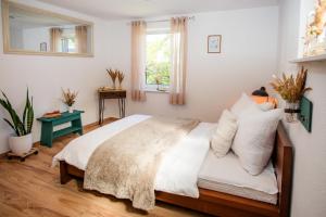 a bedroom with a bed with white sheets and pillows at Ferienhaus Peenegrün in Jarmen