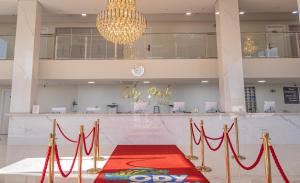 a lobby with a red carpet and a chandelier at Ody Park Resort Hotel in Iguaraçu