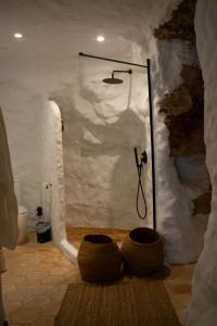 a bathroom with a shower with two tires in it at Laan Arcos, casa cueva in Arcos de la Frontera
