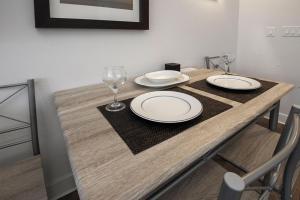 a wooden table with plates and a wine glass on it at Fraser Crossing 3518 Studio in Winter Park