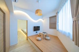 a living room with a table and a television at Yunheyue B&B in Suao