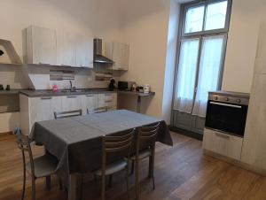 a kitchen with a table and chairs and a kitchen with a window at Da Lucia in Dronero