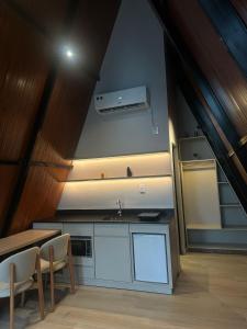 a kitchen with a sink and a table with chairs at Âmbar Chalés 2 in Ametista do Sul