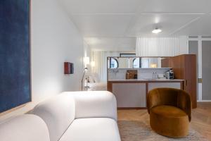 a living room with a white couch and a chair at Hotel Montaigne in Ostend