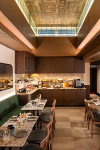 a restaurant with tables and chairs and a kitchen at Hotel Le Richemont in Paris