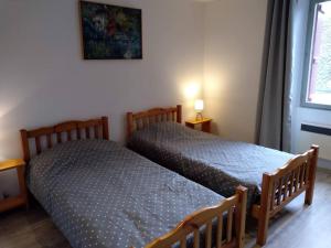 two twin beds in a room with a window at Maison Village Hautefage avec piscine chauffée in Hautefage +17 photos
