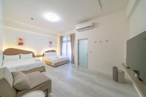 a hotel room with two beds and a couch at Yunheyue B&B in Suao