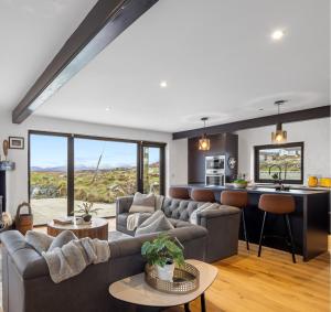 ein Wohnzimmer mit Sofa und eine Küche in der Unterkunft Garrai Locha Cottage in Roundstone