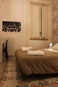 a bedroom with two beds and a desk and a picture at Alimena Retrò Rooms in Cosenza