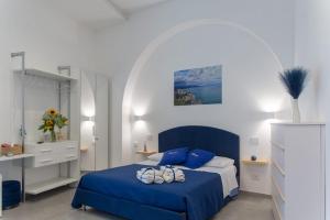 a bedroom with a blue bed in a white room at Maruzzé luxury room in Albori