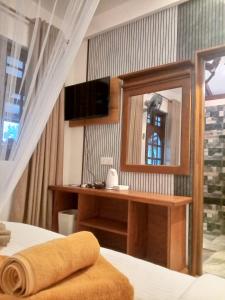 a bedroom with a bed with a mirror and a desk at H3 Hilltop Heaven in Ella