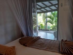 a bed in a bedroom with a open window at H3 Hilltop Heaven in Ella