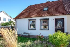 a white house with a bench in the yard at Ferienhaus Peenegrün in Jarmen