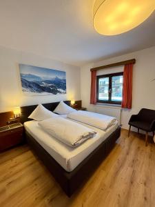 a bedroom with two beds and a large window at Hotel Egerthof B&B in Seefeld in Tirol