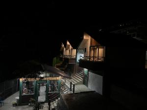 a view of a building at night with lights at Meraki Cottage in Darjeeling +3 photos