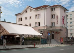 a building with a white awning next to a street at Franko hotel in Zvolen