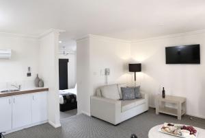ein weißes Wohnzimmer mit weißem Sofa und Bett in der Unterkunft Murray Downs Resort in Swan Hill