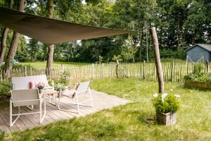 a patio with a table and chairs under a canopy at Romantic Nights Under The Thatched Roof in Scharnebeck