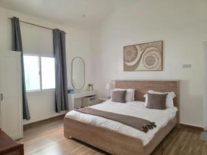 a bedroom with a large bed and a mirror at Wadi Bani Khalid - Al Joud Green Hostel in Zilaft