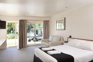 ein Schlafzimmer mit einem großen Bett und einer Couch in der Unterkunft Murray Downs Resort in Swan Hill
