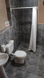 a bathroom with a toilet and a sink and a shower at Casa Qinti EcoHostel in Cosquín +54 photos
