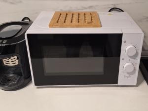 a white microwave with a wooden tray on top of it at R&R studio in Cluj-Napoca +10 photos