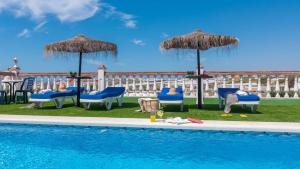 a swimming pool with chairs and umbrellas next to a pool at Villa Quevedo Torrox by Ruralidays in Torrox