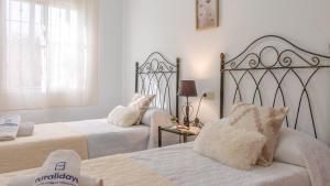a bedroom with two beds and a table with a lamp at Villa Quevedo Torrox by Ruralidays in Torrox +18 photos
