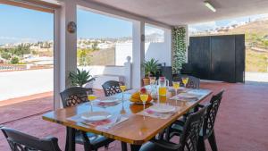 a wooden table with chairs and glasses of orange juice at Villa Quevedo Torrox by Ruralidays in Torrox