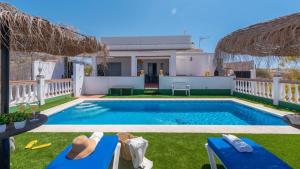 a swimming pool with blue chairs and a house at Villa Quevedo Torrox by Ruralidays in Torrox