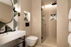 a bathroom with a toilet and a sink and a shower at Hotel Le Richemont in Paris +81 photos