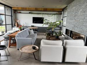 a living room with white chairs and a fireplace at Le Chateau Lavande in Balsa Nova
