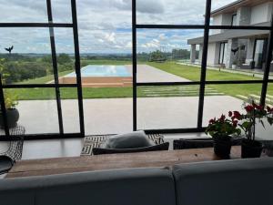a living room with a couch and a large window at Le Chateau Lavande in Balsa Nova
