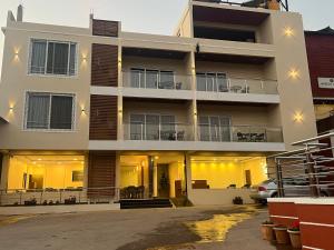 an apartment building with a car parked in front of it at Gugal Bliss in Mahabaleshwar