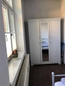 a bedroom with a white cabinet and a window at Gutshaus Breesen in Laage