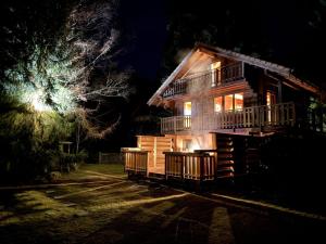 a log cabin at night with the lights on at LE GRIZZLY Chalet en bois avec SPA Jacuzzi in La Bresse