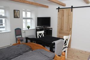 a bedroom with a bed and a tv and a door at 1st floor 2 rooms with kitchenette in Store Heddinge