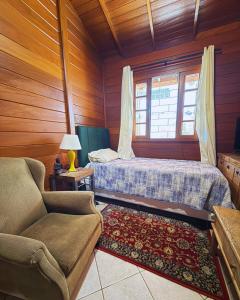 a bedroom with a bed and a couch and a window at EcoVibe House Florianópolis in Florianópolis