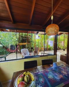 a dining room with a table with a bowl of fruit at EcoVibe House Florianópolis in Florianópolis