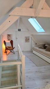 a attic bedroom with a bed and a chair at Le Royal Billy in Dreux