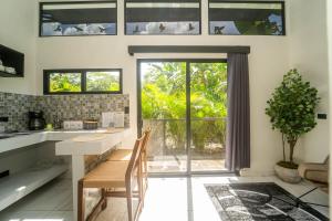 eine Küche mit Tisch und Stühlen und einem Fenster in der Unterkunft Inta Tiny House in Fortuna