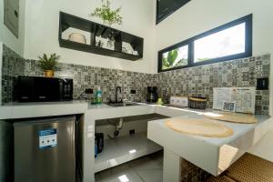 eine Küche mit Spüle und Mikrowelle in der Unterkunft Inta Tiny House in Fortuna + 5 Fotos
