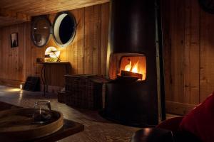 a fireplace in a wooden room with a fire in it at Péniche de charme, Avignon, Provence in Villeneuve-lès-Avignon