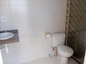 a bathroom with a toilet and a sink at J U N Q U E I R A i in Mangaratiba +28 photos