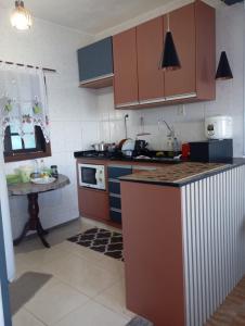 a kitchen with brown cabinets and a counter top at J U N Q U E I R A i in Mangaratiba