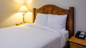 a bedroom with a bed with a wooden headboard and a lamp at Cahilty #434 home in Sun Peaks