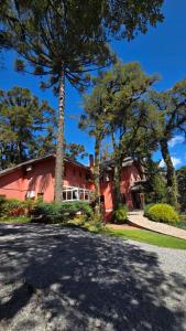 a red house with trees in front of it at Pousada Pinhão e Poesia in Canela +25 photos