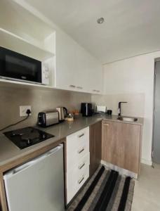 a kitchen with a stove and a microwave at CityNest Hotel Apartment in Cape Town