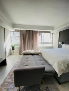 a bedroom with a large bed and a large window at CityNest Hotel Apartment in Cape Town